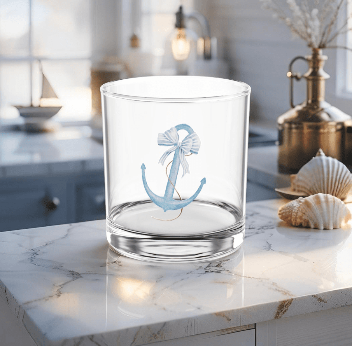 Cocktail glass with light blue anchor design on coastal table