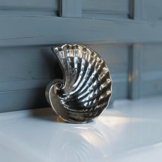 Beach-themed ceramic shell soap holder on a vanity counter