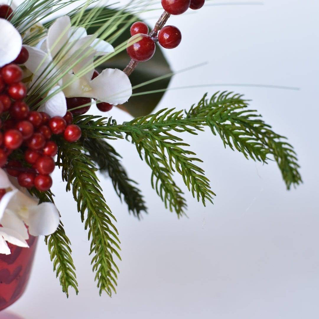 Luxury hostess gift idea: Christmas floral display in a red vase with white flowers.