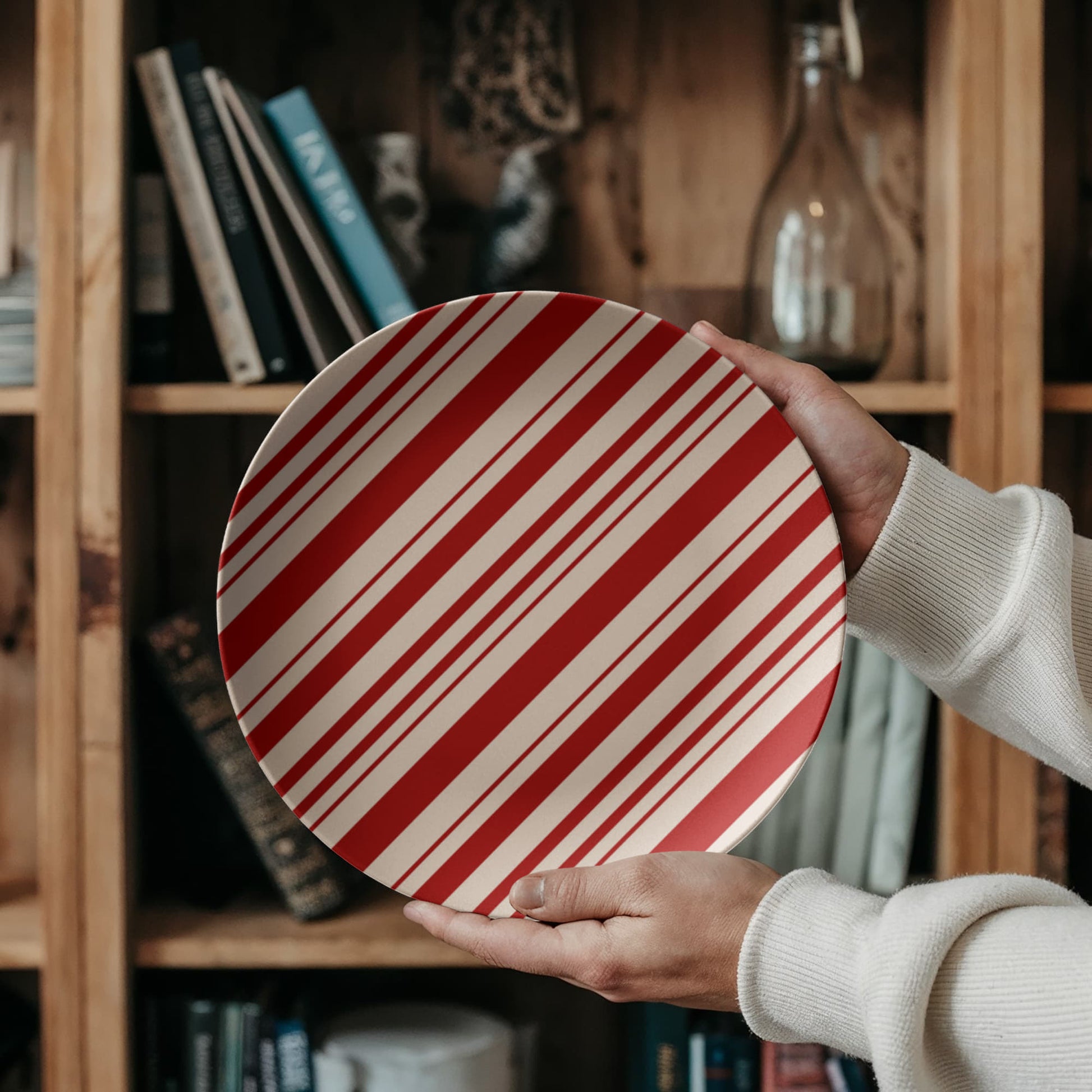 Close-up view of the smooth ceramic texture and vibrant red peppermint stripe pattern on the dinner plate.