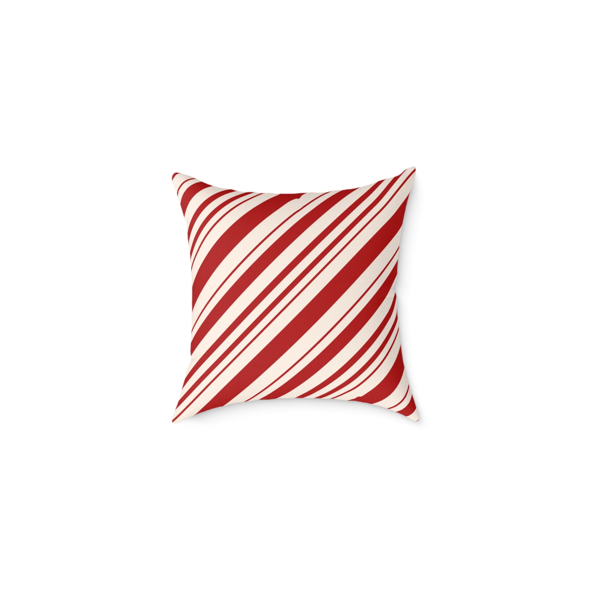 Red and white striped Christmas throw pillow styled on a cozy gray sofa with a holiday blanket.