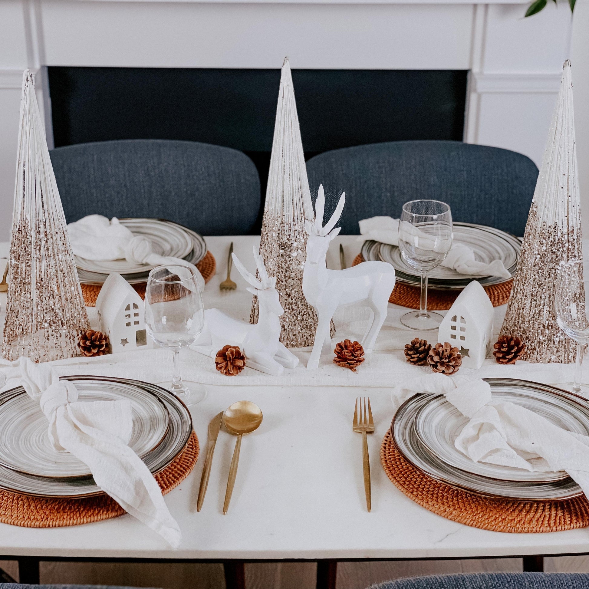 Close-up of sparkle gold Christmas decor mini trees (cone shape) on a wooden surface.