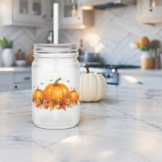 Mason jar tumbler with pumpkin design on a kitchen counter