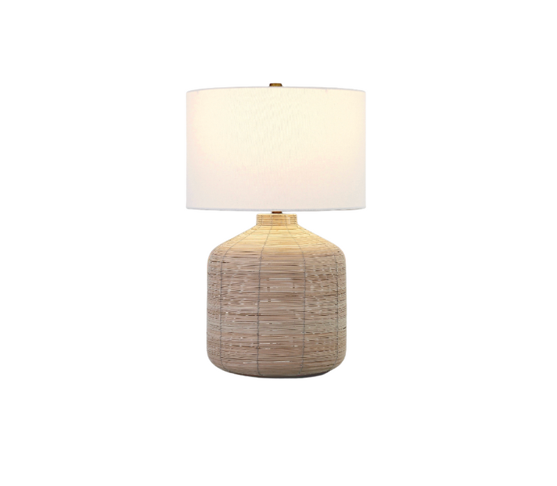 Table lamp with a textured base and white shade on a white background