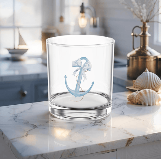Cocktail glass with light blue anchor design on coastal table