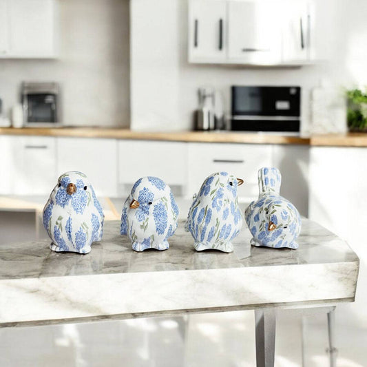 Blue hydrangea resin bird figurine perched on a white bookshelf with plants and blue accents.