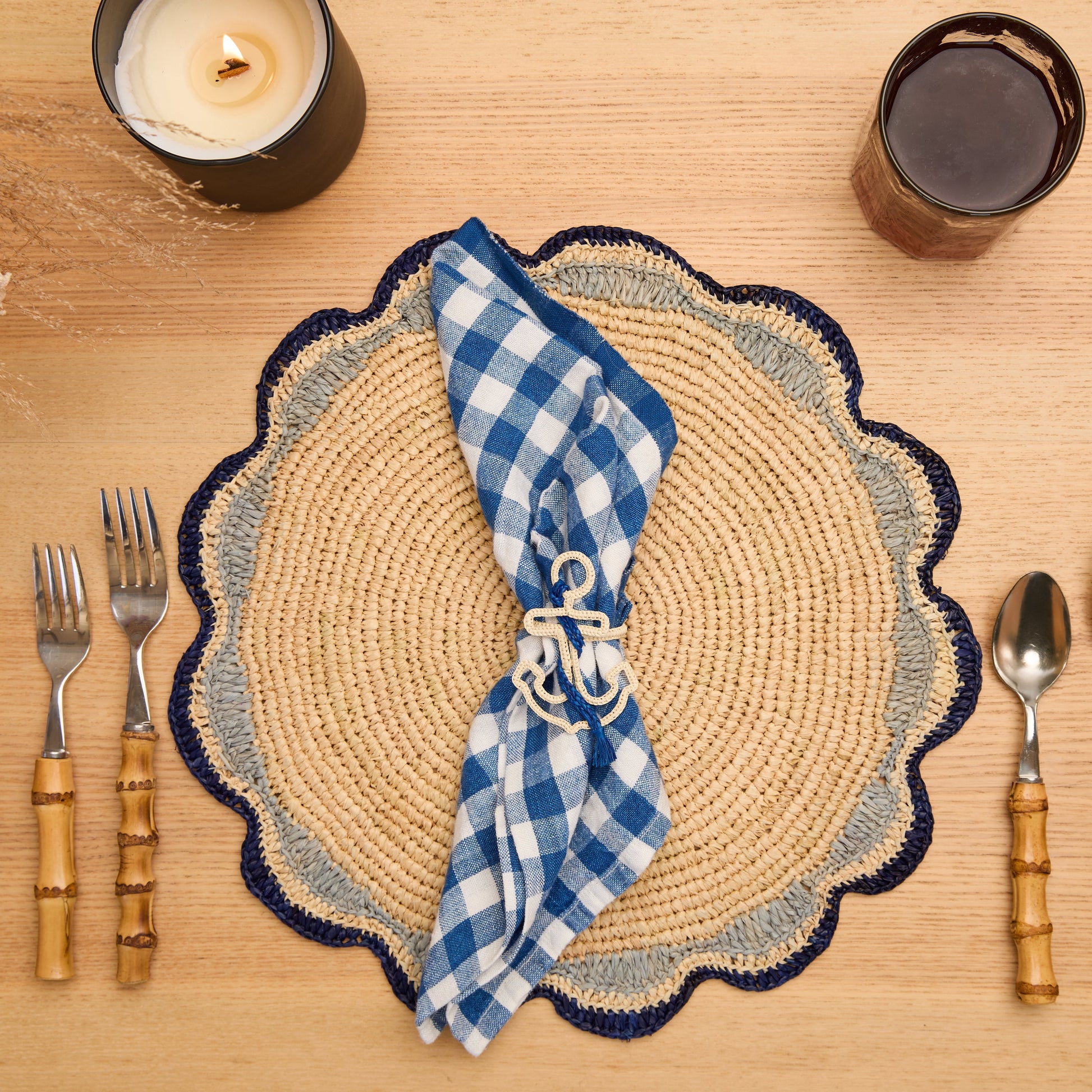 Single blue and white nautical anchor napkin ring on a linen napkin for summer table settings.
