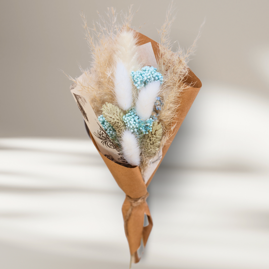 Breezy blue mini dried floral arrangement displayed on a white office desk; a charming, zero maintenance decor piece.
