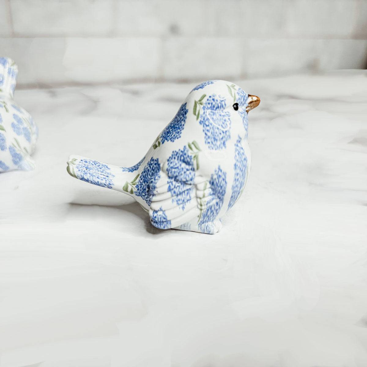 Close-up of the intricate blue hydrangea design on the coastal decorative bird accent.