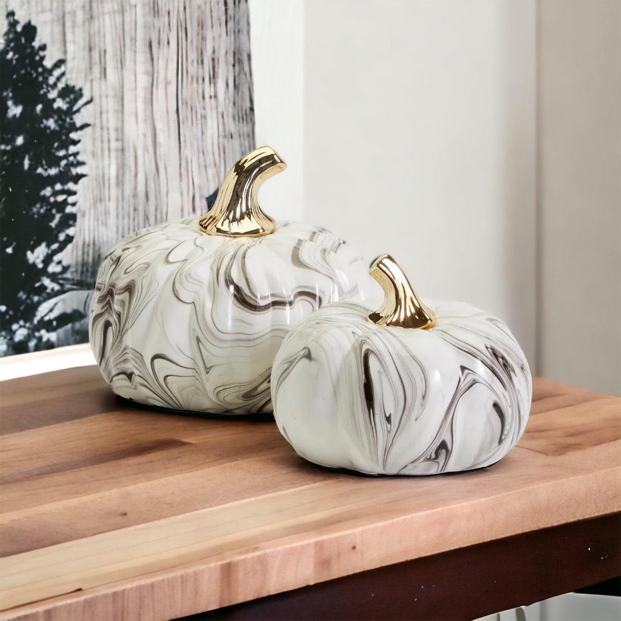 Glam Halloween marbled pumpkin set with gold stem displayed on a white fireplace mantel.