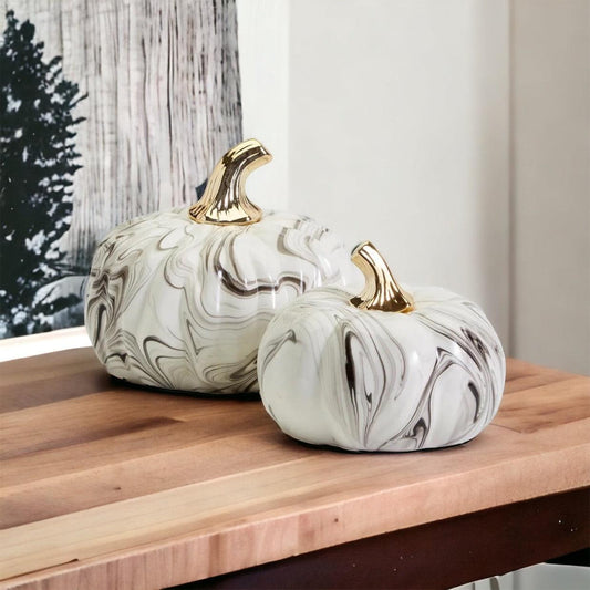 Glam Halloween marbled pumpkin set with gold stem displayed on a white fireplace mantel.