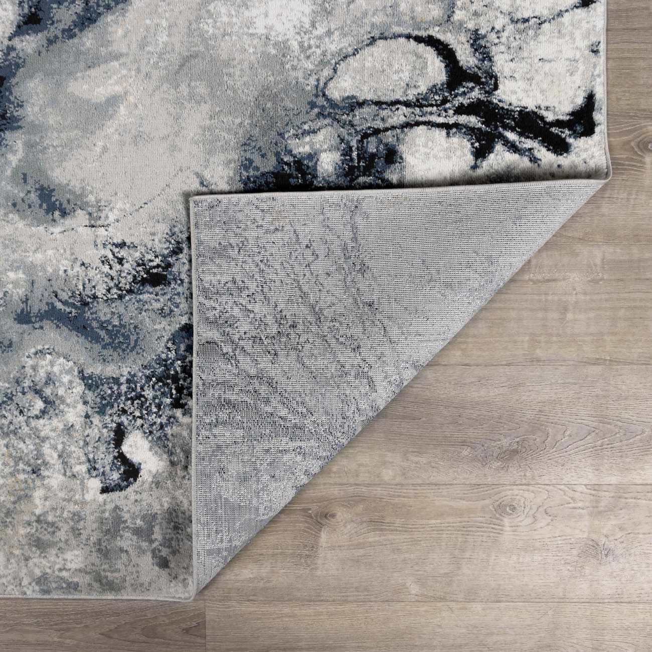 Modern low-pile rug displayed in a living room setting, showcasing its size and contemporary style.