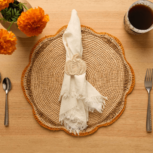 Set of 4 handwoven rattan pumpkin napkin rings for a rustic Thanksgiving table setting.
