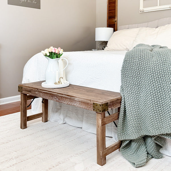 Distressed reclaimed wood folding bench in a farmhouse-style setting