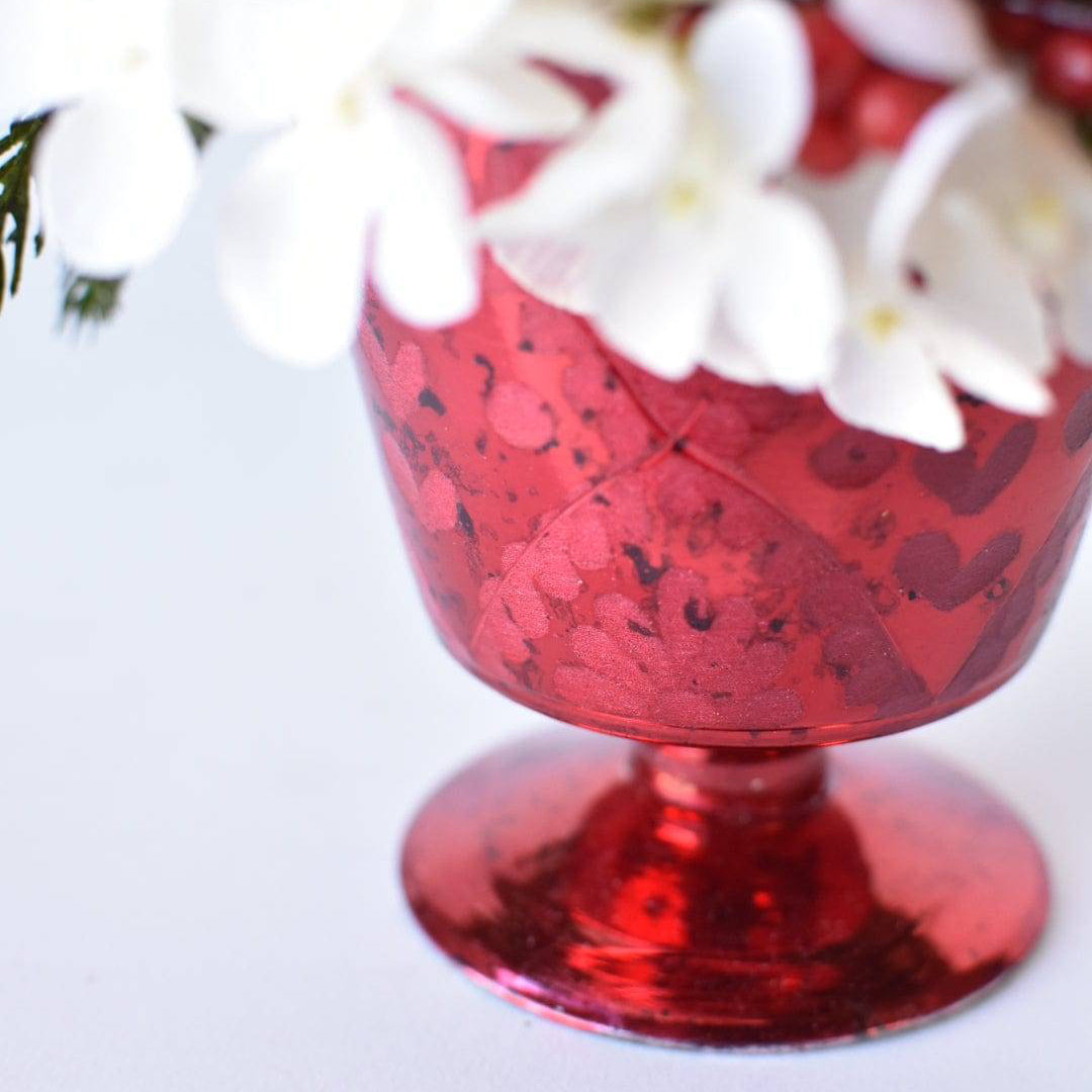 Red and white Christmas table centerpiece with faux hydrangea floral arrangement.