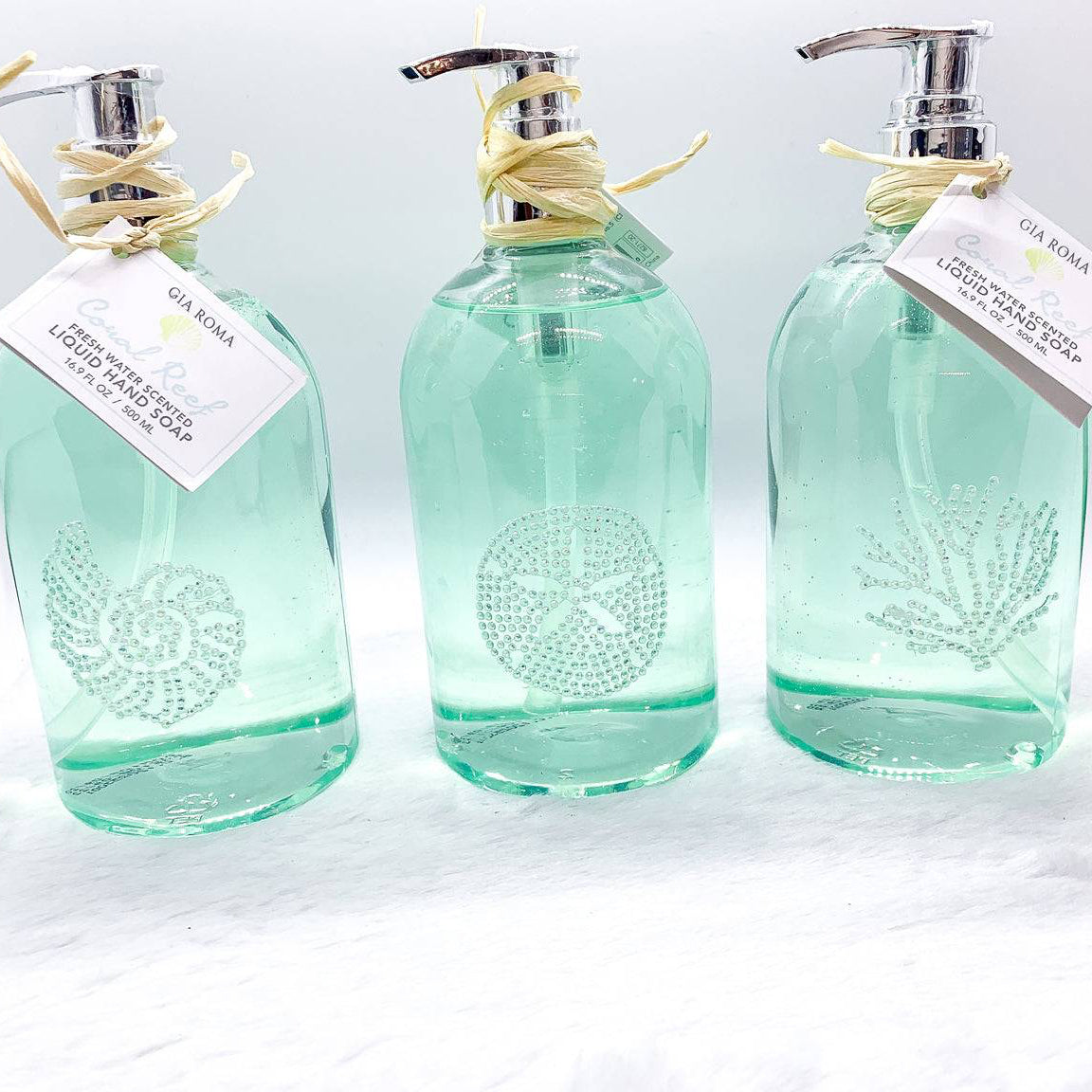 Close-up of the refillable teal soap pump bottle with hand soap, highlighting its eco-friendly, reusable design.