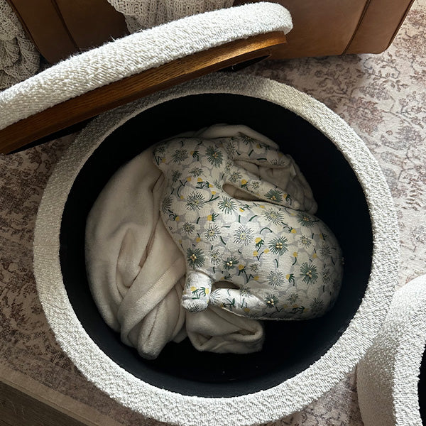Round boucle ottoman with lid lifted showing hidden storage compartment