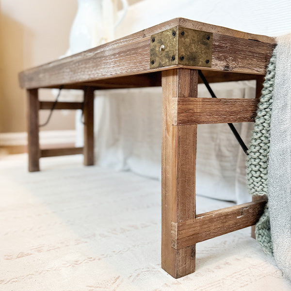 Distressed reclaimed wood folding bench in a farmhouse-style setting
