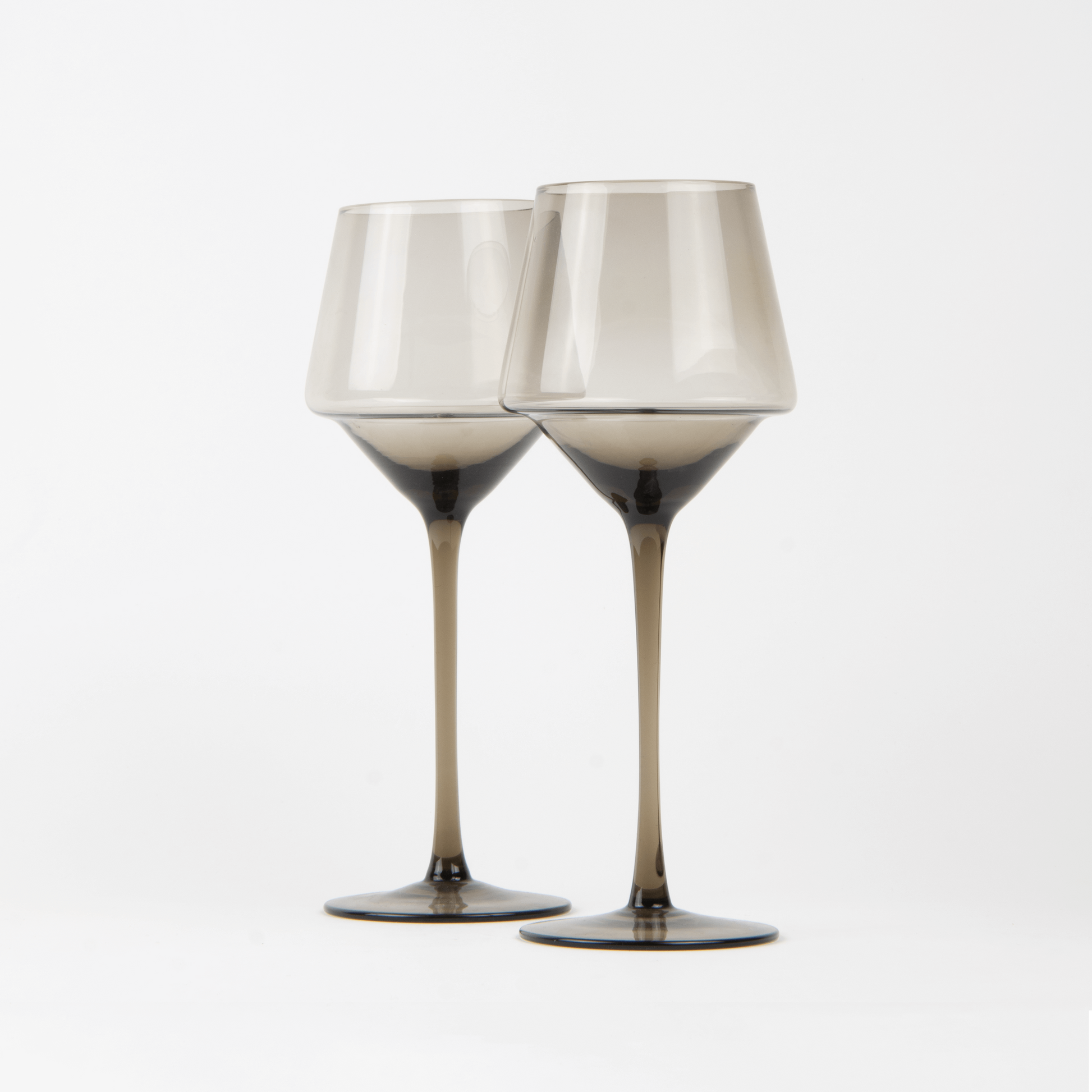 Two wine glasses with metallic accents on a white background