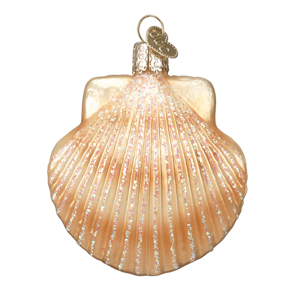 Sparkly gold seashell ornament hanging on a green Christmas tree with white lights.