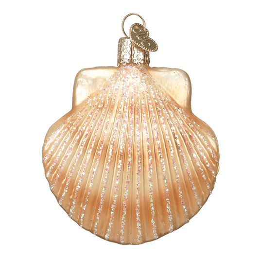 Sparkly gold seashell ornament hanging on a green Christmas tree with white lights.